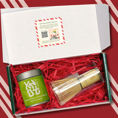 Gift set with a green tea canister and wooden whisk on red and white striped paper