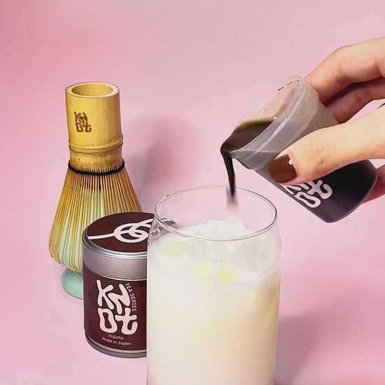 Hojicha latte pour with pink background